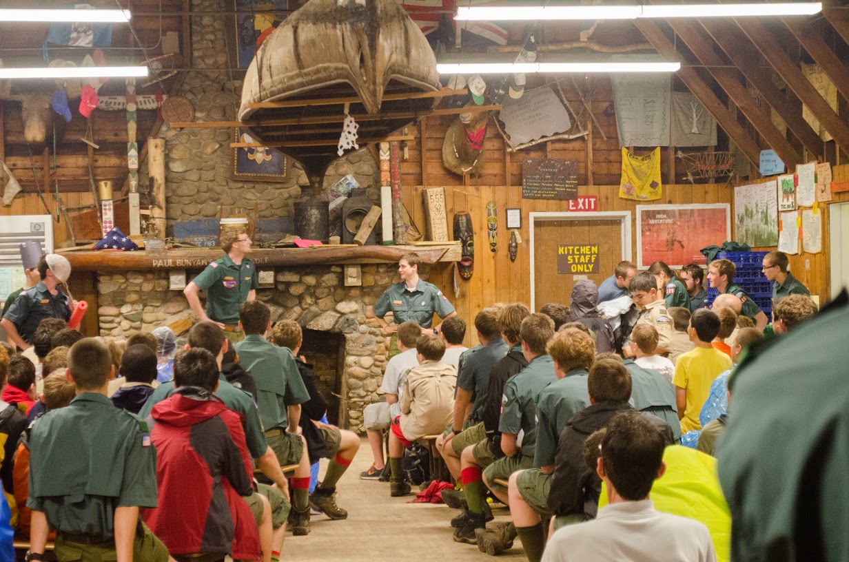 Scouts sit in the dining hall, paying attention to a speaker